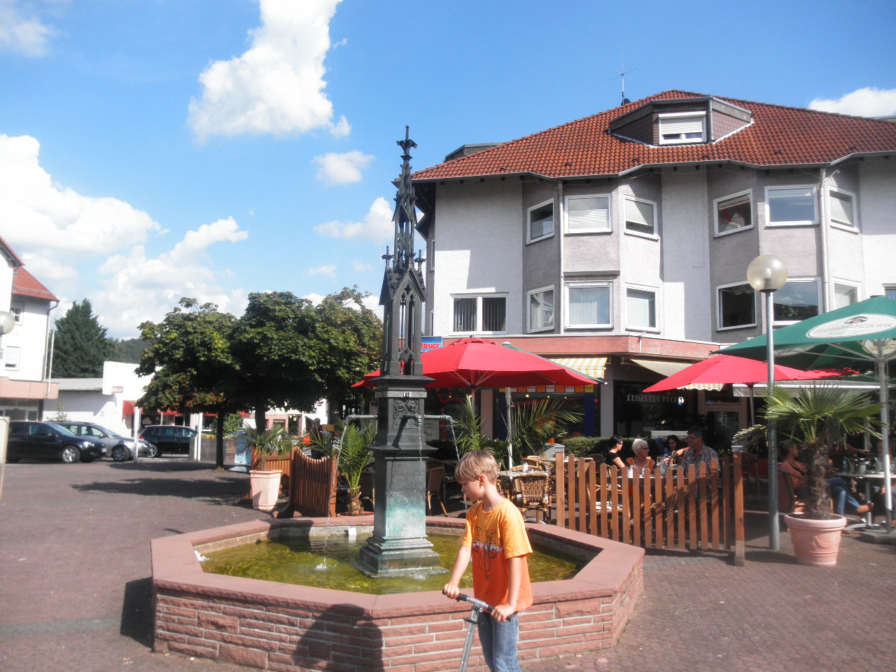 Blick über den zentralen Platz von Höchst im Odenwald: Gepflasterter Marktplatz mit Brunnen. Typische Odenwälder Putz- und Fachwerkhäuser.