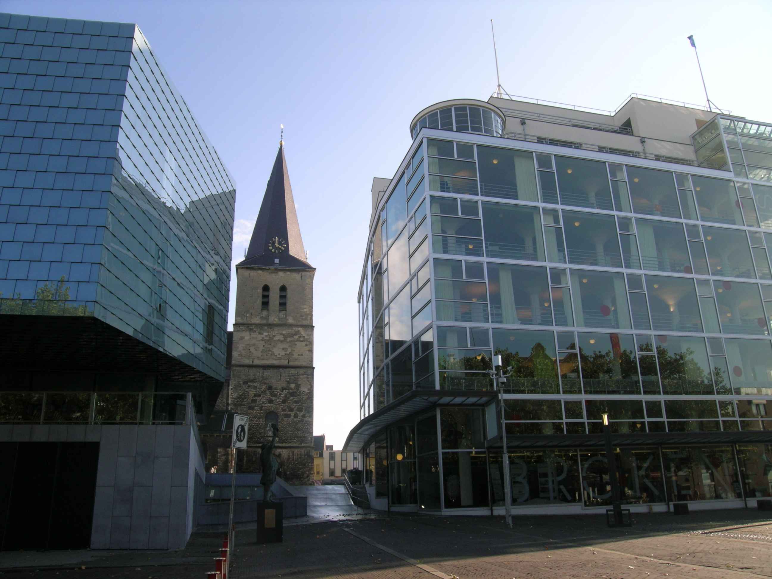 Glaspaleis in Heerlen mit moderner Glasfassade neben Kirche und Musikschule